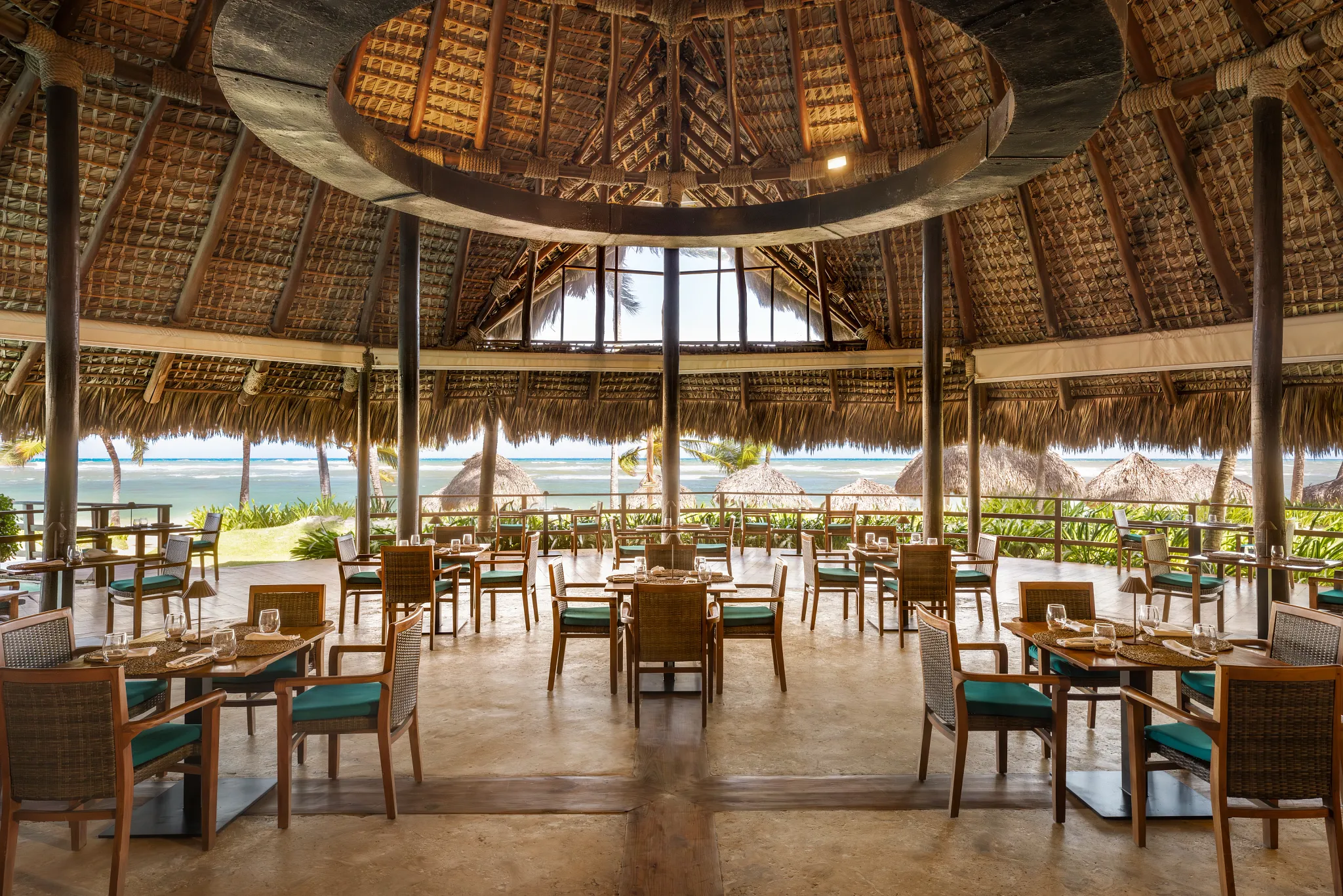 Indigo Restaurant at Zoëtry Agua Punta Cana featuring open-air palapa dining, ocean views, and elegant tropical seating.